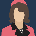 icomania:A woman with a pink hat and suit on and short brown hair.